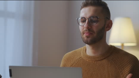 male-specialist-is-speaking-at-online-meeting-with-colleagues-communicating-with-people-distantly-from-home-portrait-of-man-in-room